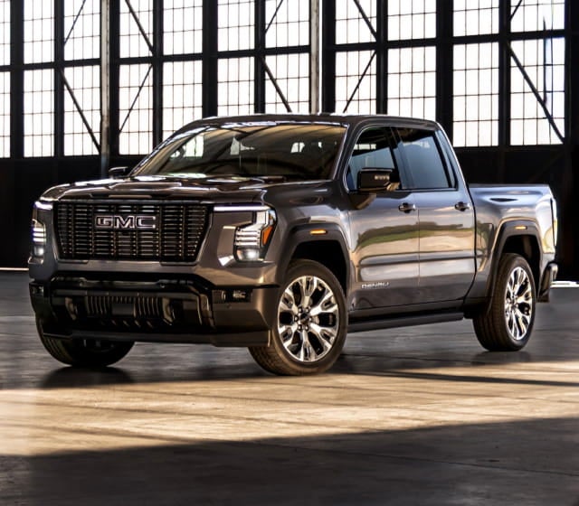Gray GMC Sierra 1500 pickup truck displayed inside an industrial-style building.